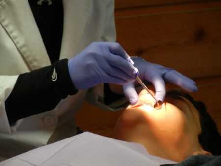 Implantolog-stomatolog przeprowadza badanie dentystyczne