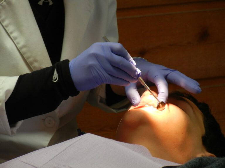 Implantolog-stomatolog przeprowadza badanie dentystyczne